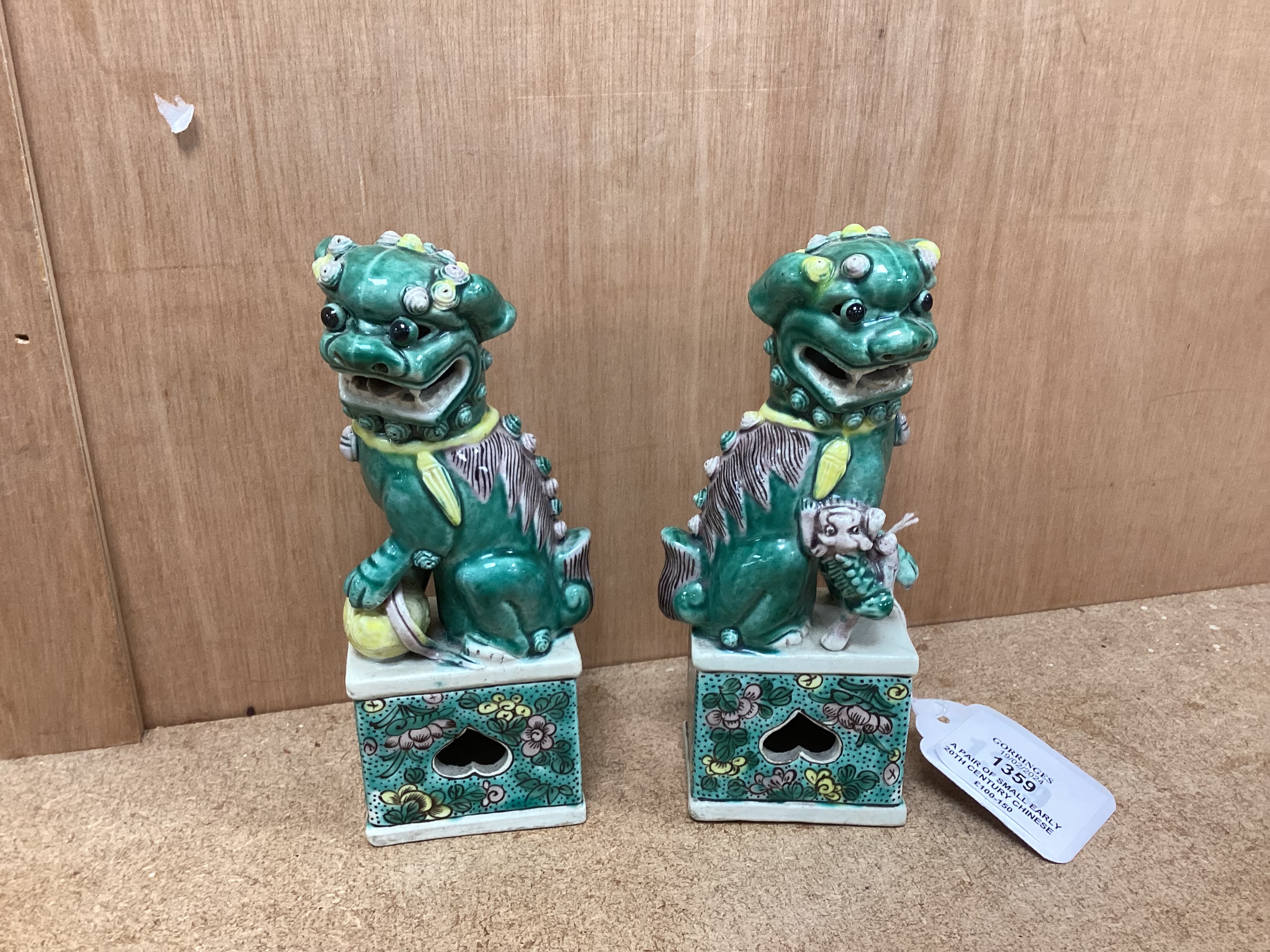 A pair of small early 20th century Chinese figures of Buddhist lions, 15.5cm high